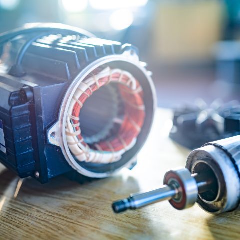 Close-up of an iron industrial motor lies on a table during the production of new modern trucks in a factory. The concept of reliable and high-quality special cars